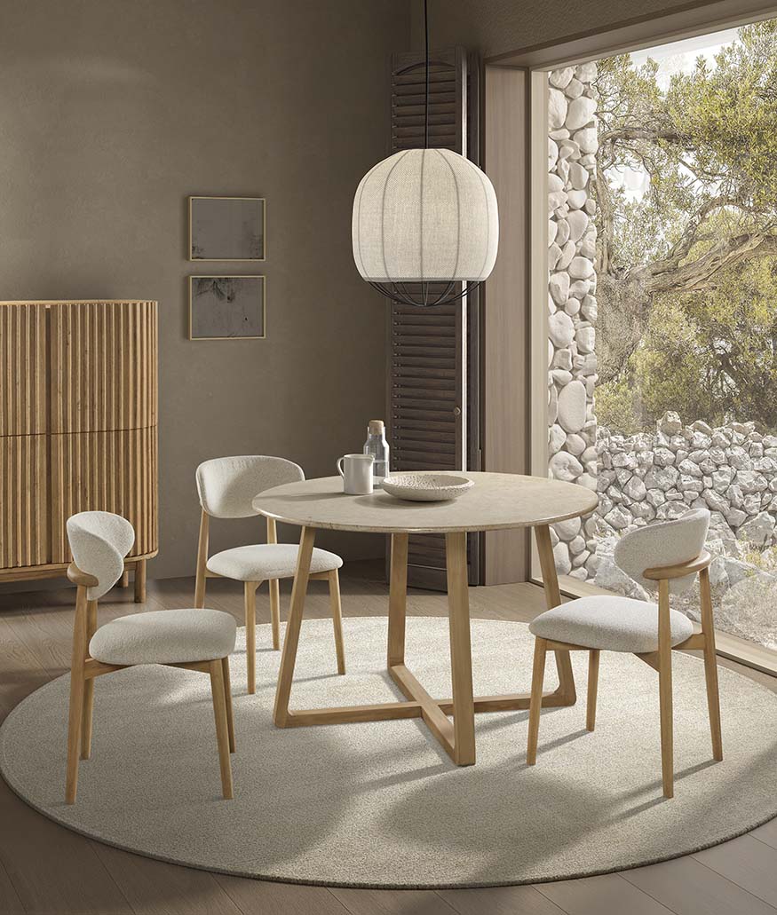 Mesa de comedor redonda con tapa de piedra clara y base cilíndrica de madera natural con ranuras verticales, diseño Japandi elegante ideal para espacios serenos y contemporáneos. Boutique Interiorismo.
