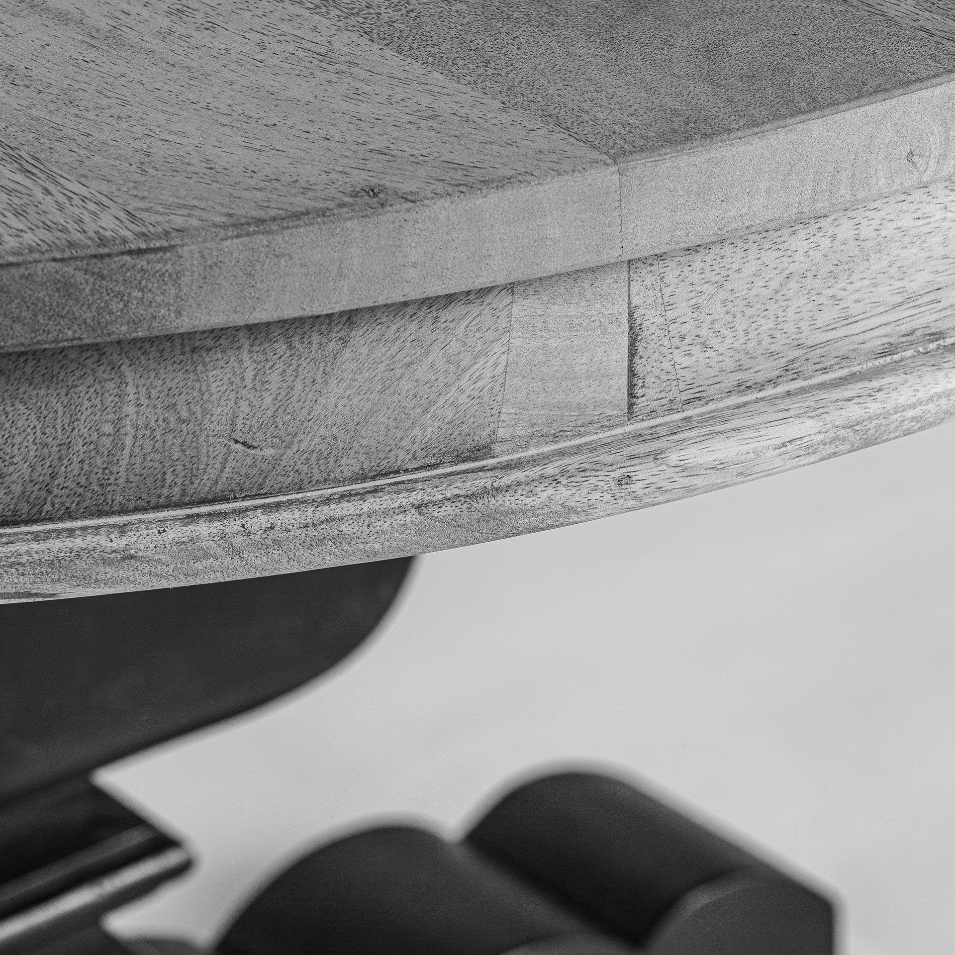 Detalle del tablero redondo en madera de mango natural con vetas marcadas y acabado artesanal.