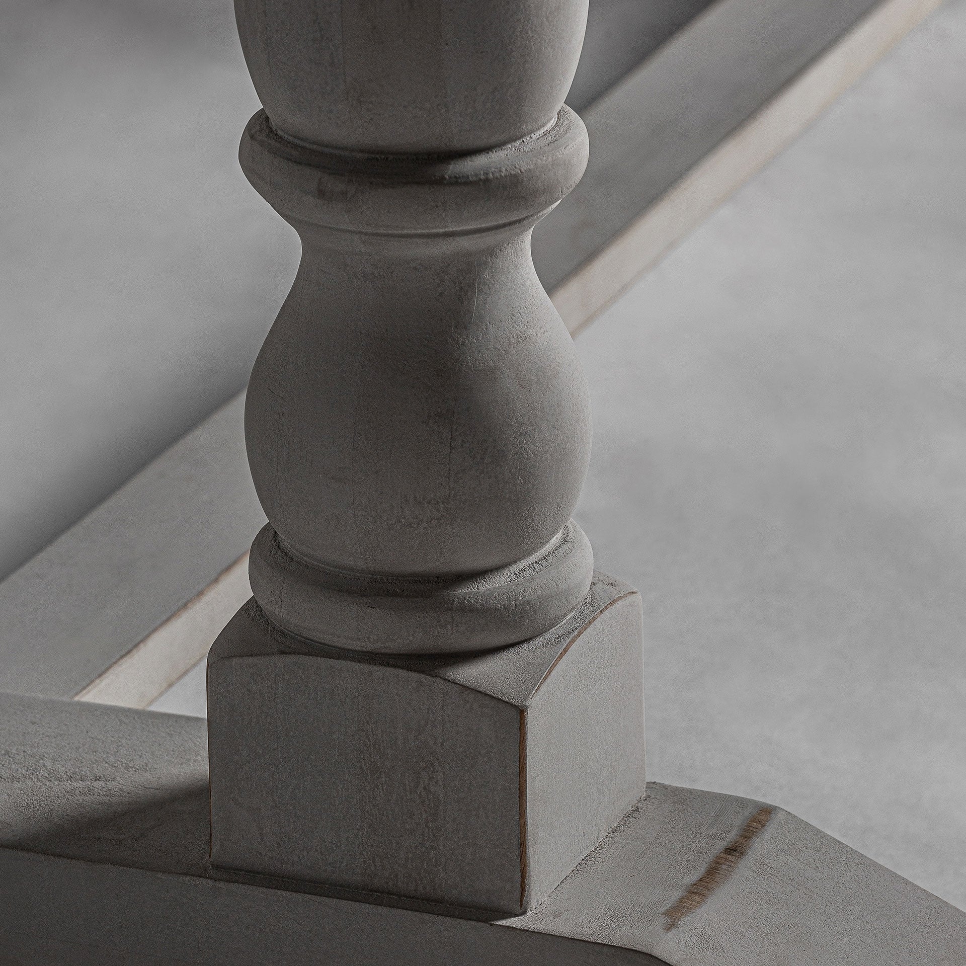 Pata blanca torneada de madera con acabado envejecido, detalle artesanal de la mesa comedor Cirella.