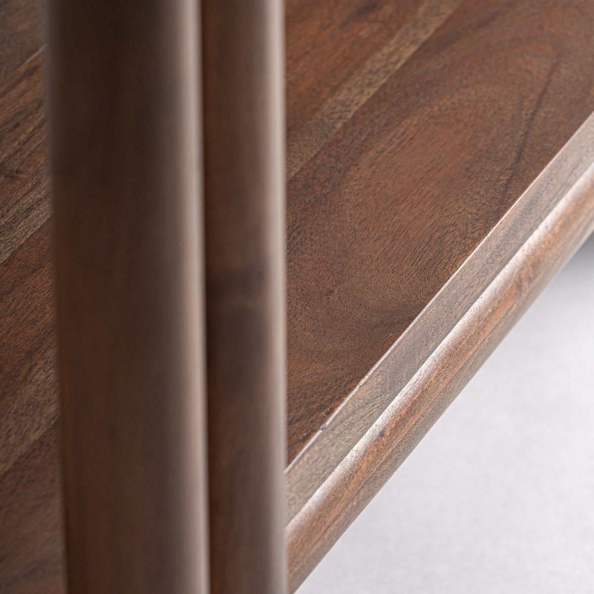 Detalle lateral de la estantería Hambye con estructura de tubo redondo y uniones visibles, acabado cálido en madera, boutique interiorismo VICAL.