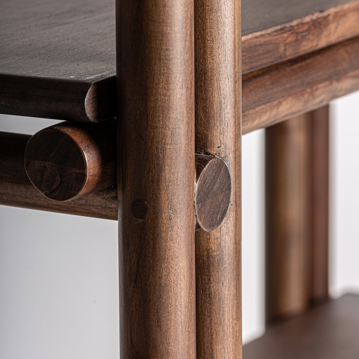 Vista cercana de la estructura tubular redonda en madera de nogal de la estantería Hambye, uniones artesanales, boutique interiorismo VICAL.