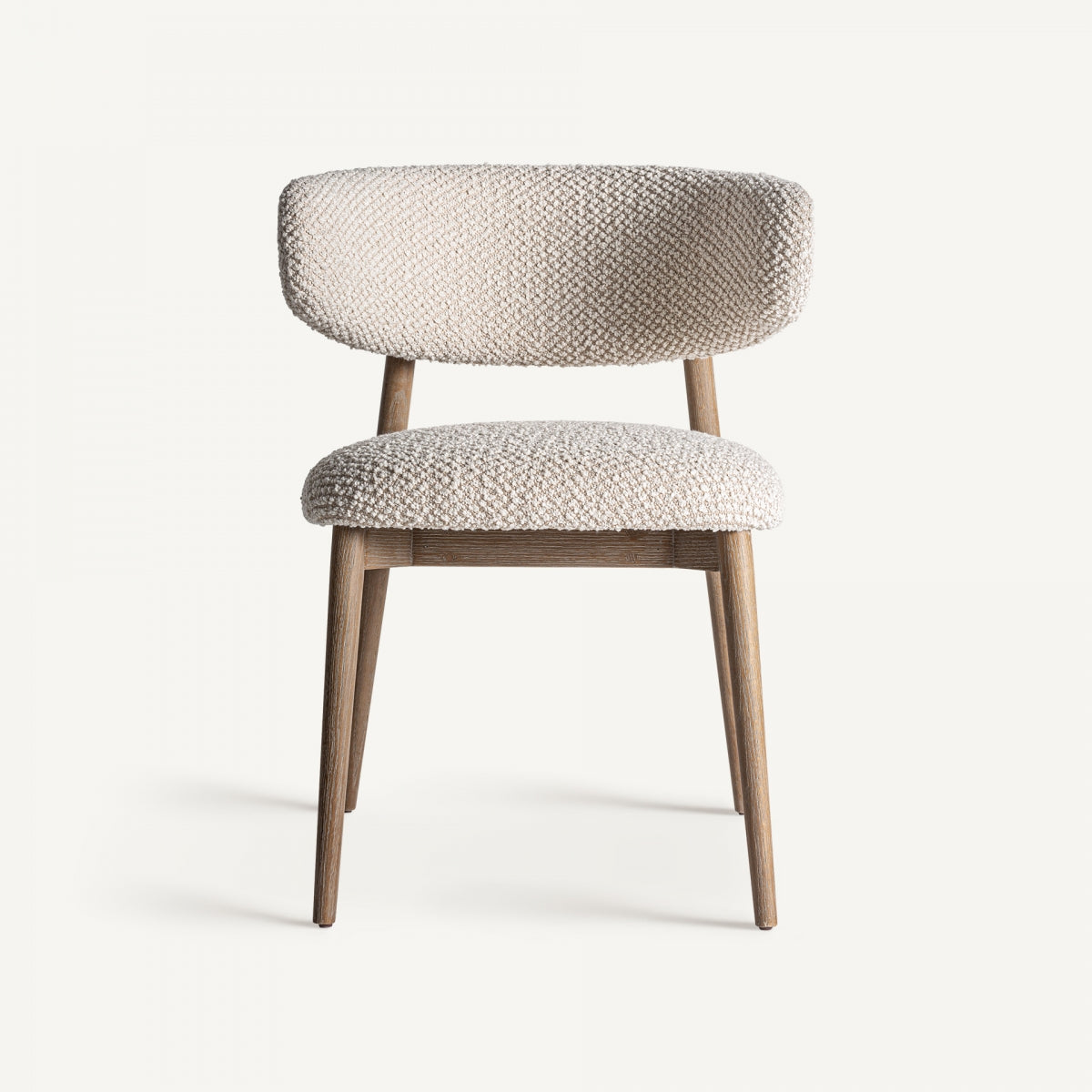 Silla Glorenza vista frontal, diseño envolvente tapizado en bouclé natural y patas de madera de roble