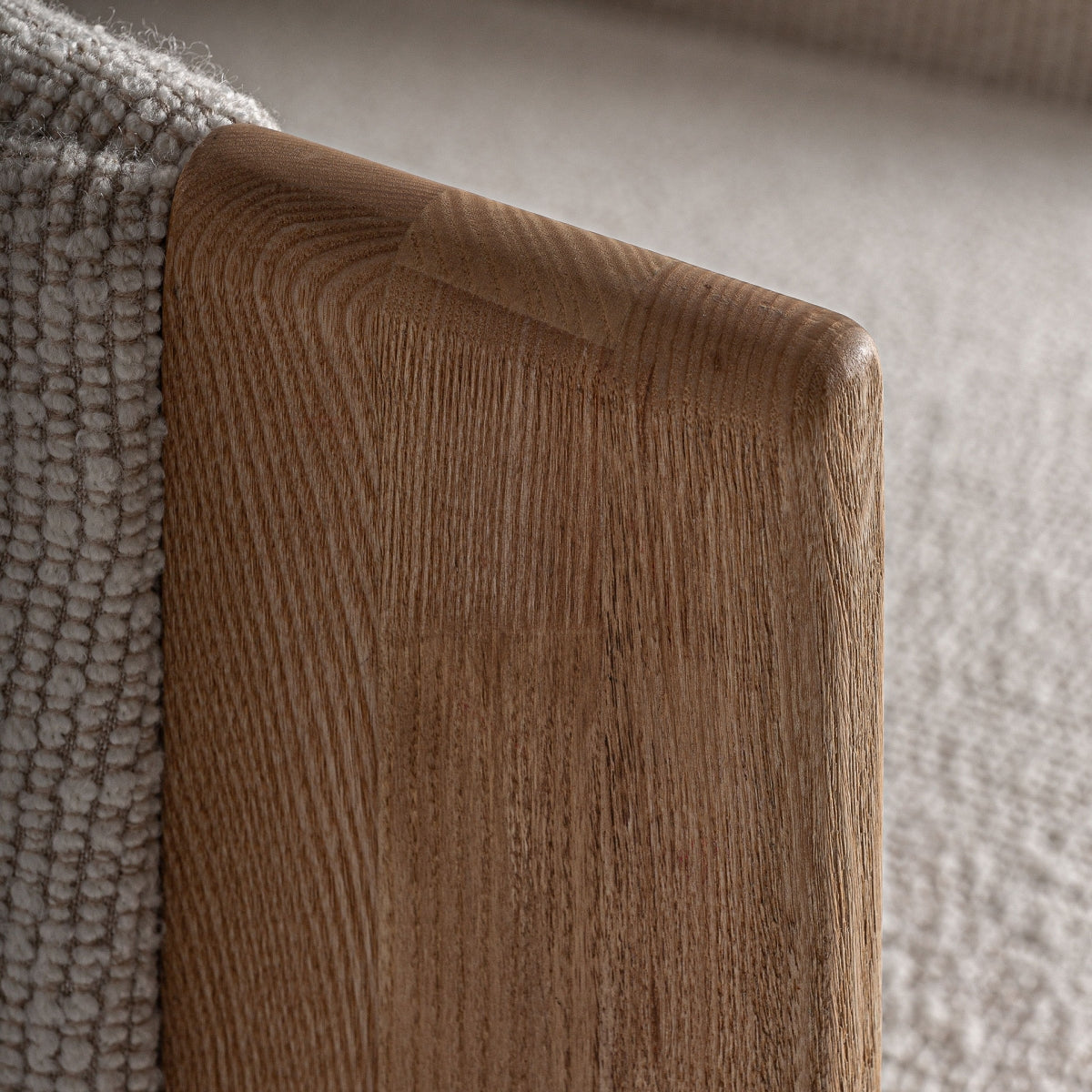 Primer plano del reposabrazos de madera del sillón Nara con acabado suave y vetas visibles