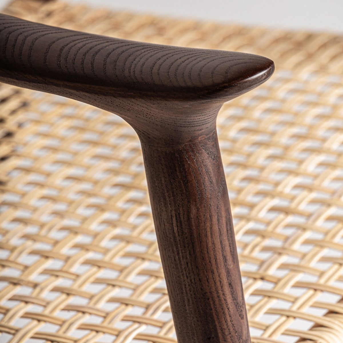 Detalle del brazo tallado en madera oscura con acabado natural y forma orgánica
