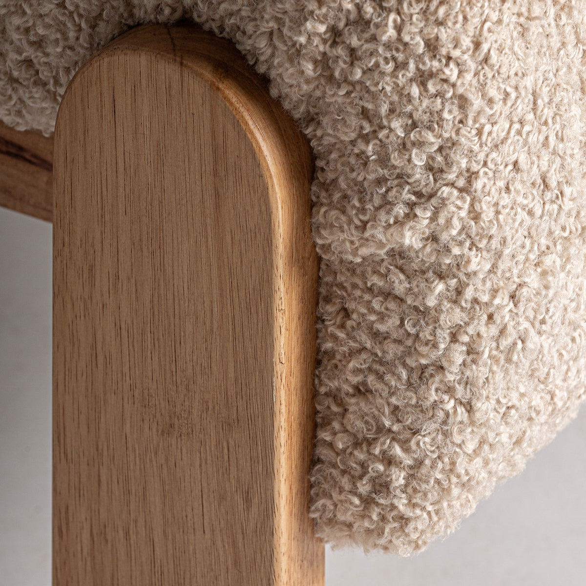 Detalle de pata redondeada en madera natural de la butaca Neyprat, acabados nobles y artesanales