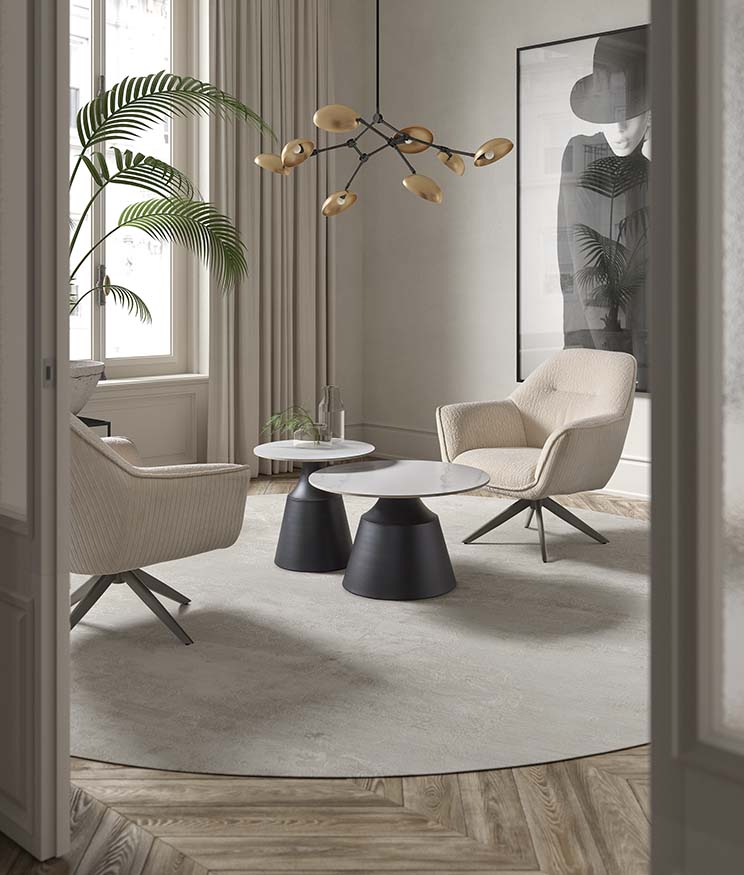 Mesa auxiliar redonda de madera natural con tapa lisa y patas verticales unidas por estructura inferior circular, diseño escandinavo versátil ideal para salones o dormitorios con estilo cálido. Boutique Interiorismo.