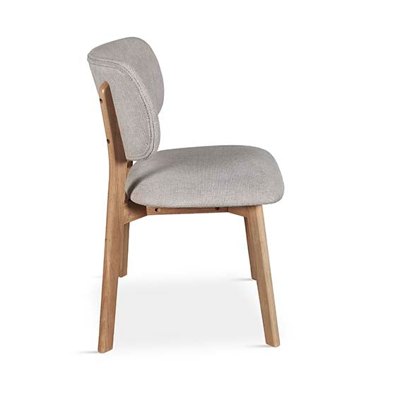 Silla de comedor con respaldo curvo de madera y asiento tapizado en tono neutro, diseño escandinavo cómodo y elegante ideal para espacios modernos. Boutique Interiorismo.