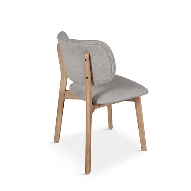 Silla de comedor con respaldo curvo de madera y asiento tapizado en tono neutro, diseño escandinavo cómodo y elegante ideal para espacios modernos. Boutique Interiorismo.