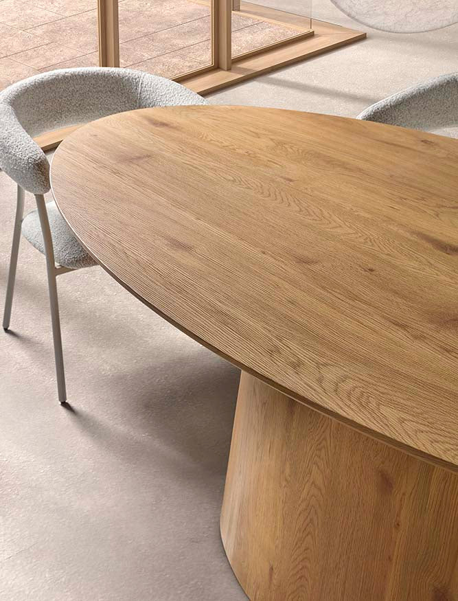 Ambiente elegante con mesa ovalada de madera y sillas tapizadas — comedor cálido y sofisticado por Boutique Interiorismo.