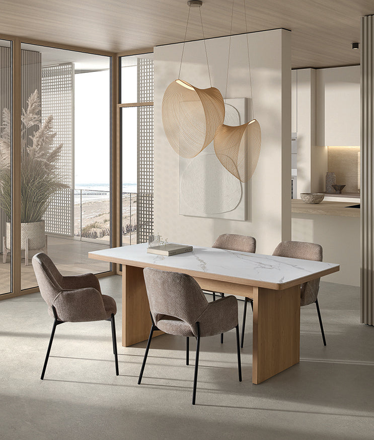 Ambiente costero con suelo de madera clara y mesa blanca de base escultórica — equilibrio natural por Boutique Interiorismo.
