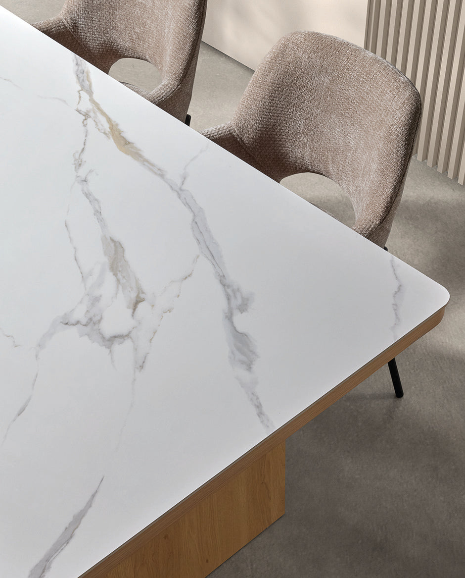 Detalle superior del sobre porcelánico blanco vetado — lujo atemporal y textura natural en mesas de Boutique Interiorismo.