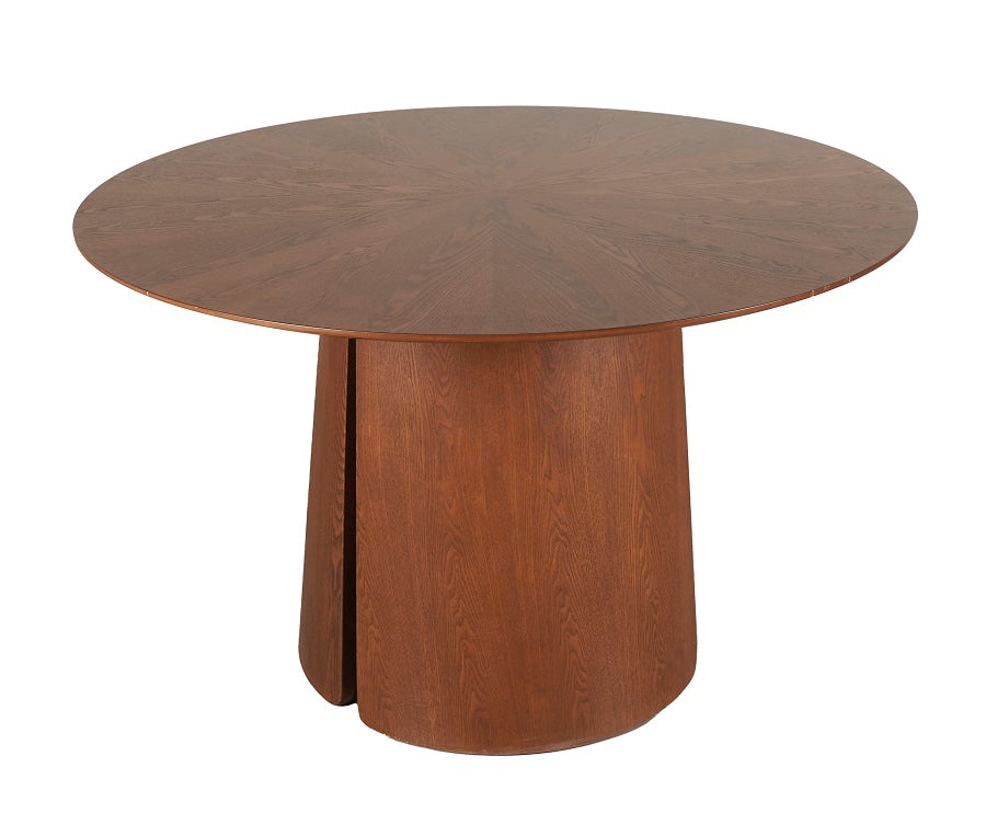 Mesa comedor redonda en nogal con base cilíndrica maciza — elegancia cálida con presencia contemporánea de Boutique Interiorismo.
