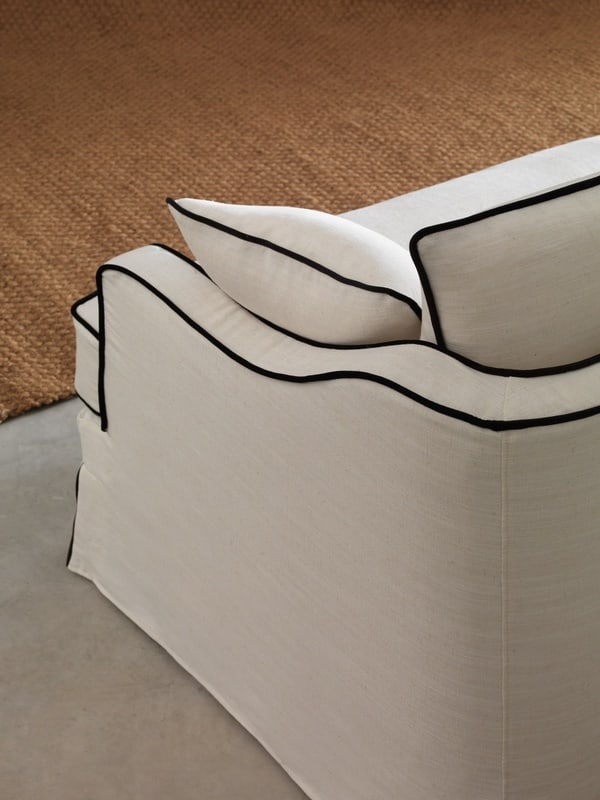 Detalle del sofá Grecia en blanco con vivo negro, estilo clásico chic con acabados elegantes. Perfecto para ambientes sofisticados y luminosos.