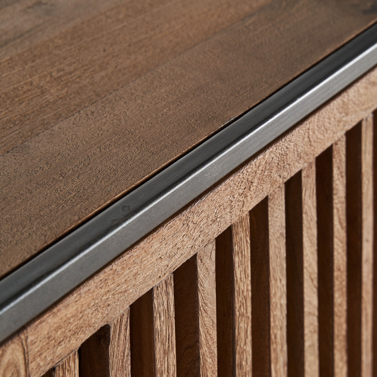 Detalle de la tapa superior en madera natural con borde metálico.