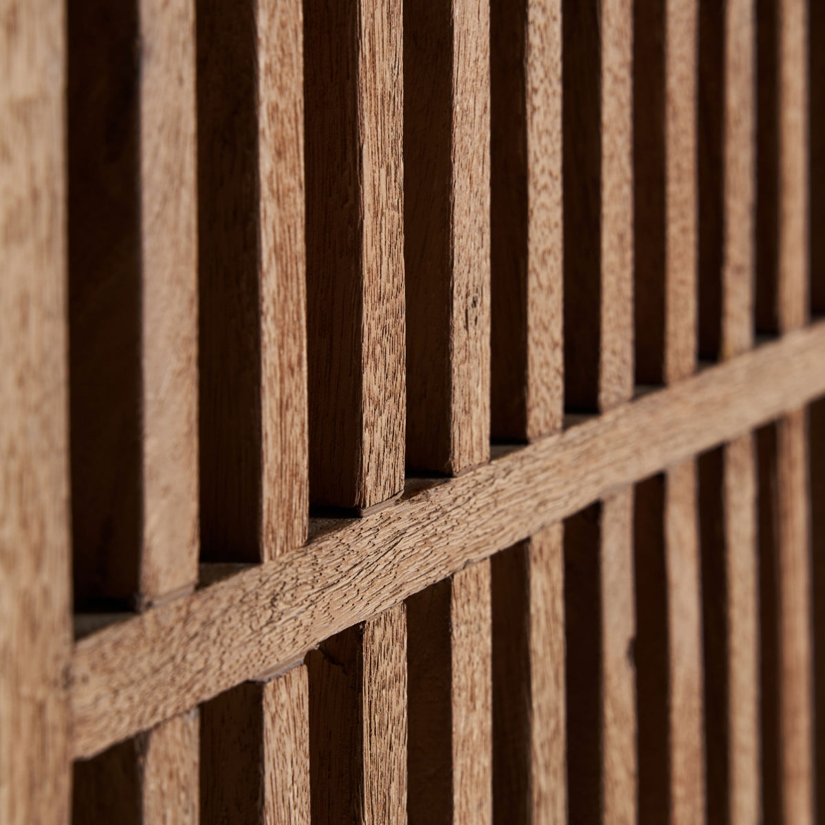 Primer plano de la rejilla decorativa de madera natural en disposición vertical.