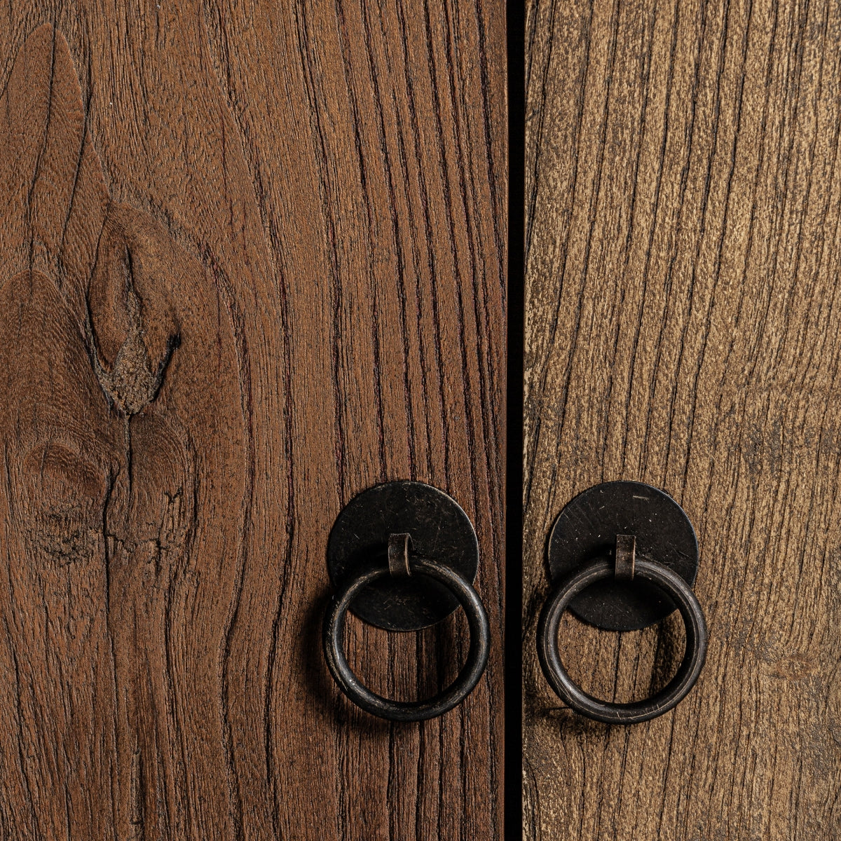 Detalle de los tiradores metálicos circulares sobre madera veteada de olmo