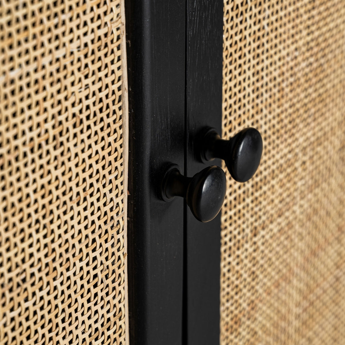 Detalle de los tiradores en negro sobre puertas de ratán.