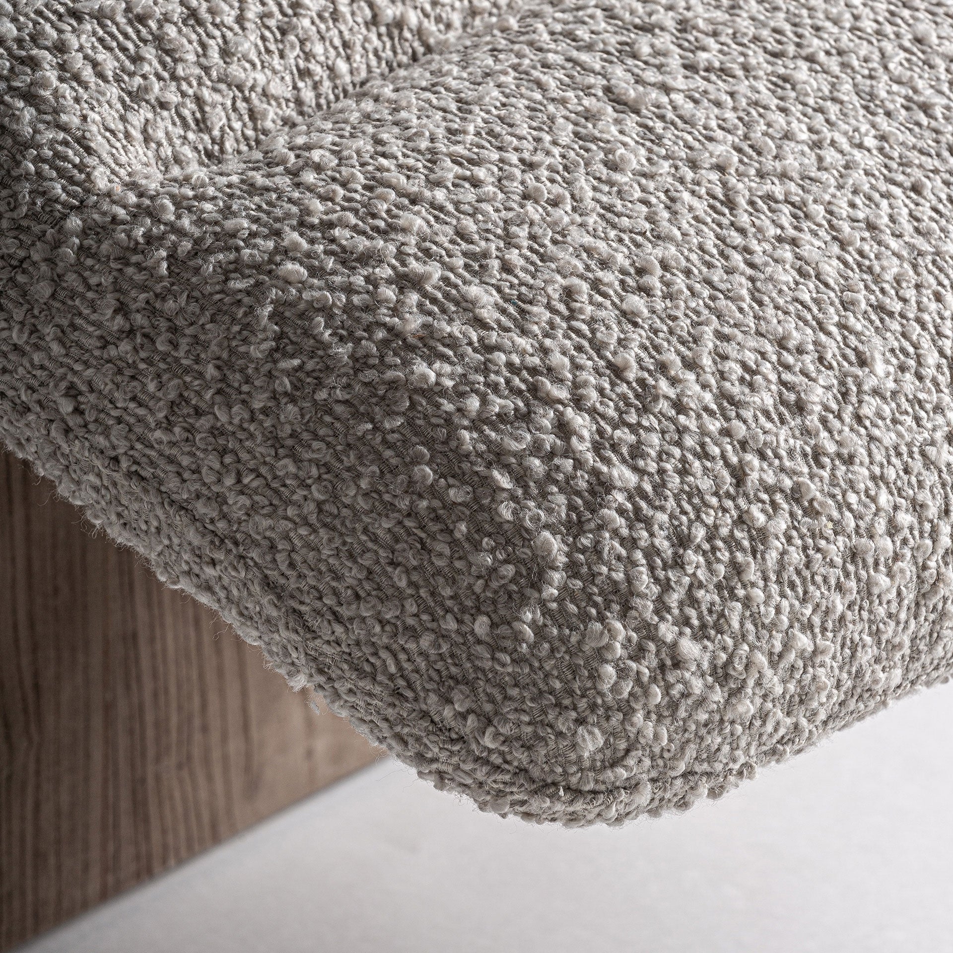 Detalle de tejido bouclé en color beige. Textura suave y acogedora del tapizado.