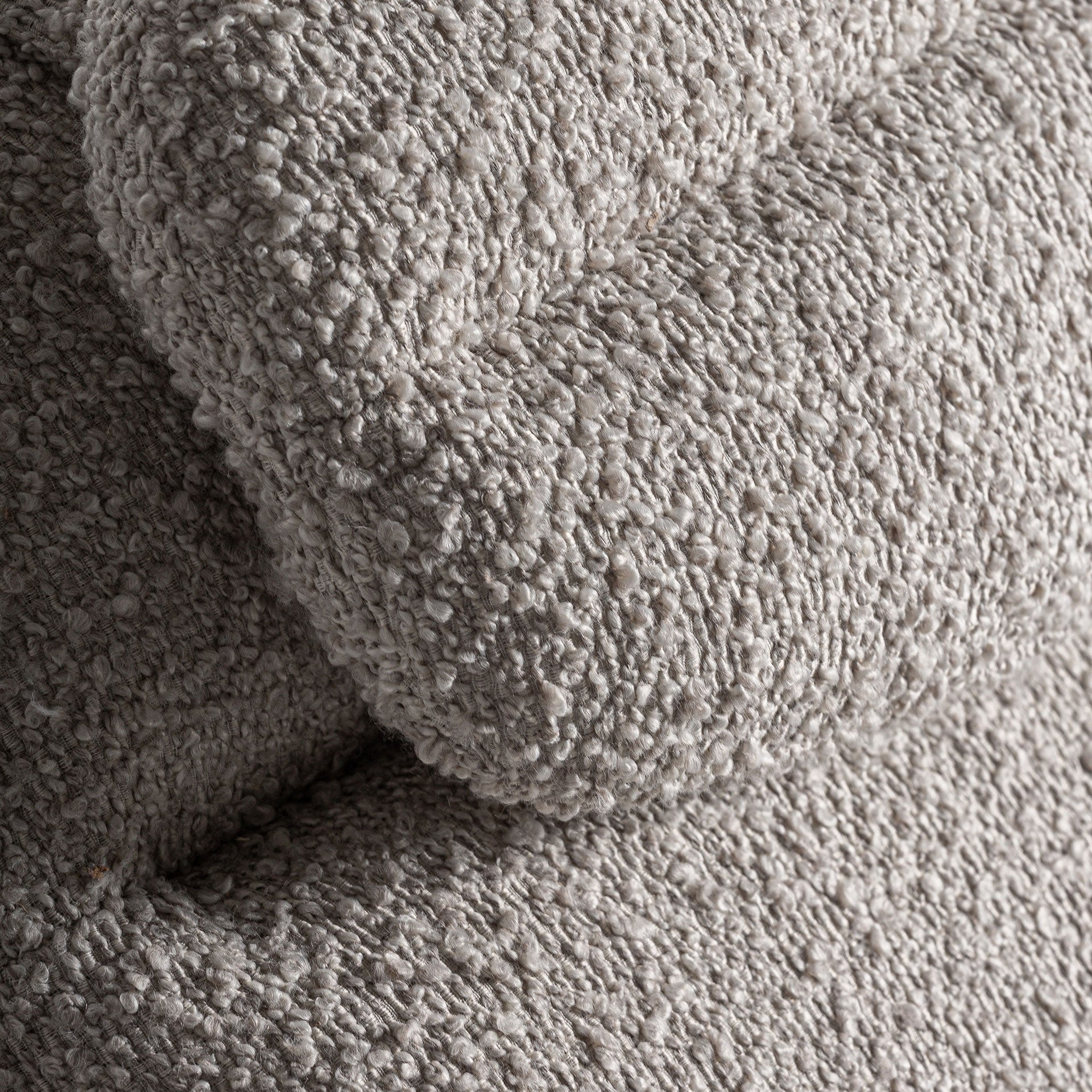 Cojín de cabeza integrado en chaise longue con textura mullida bouclé beige.