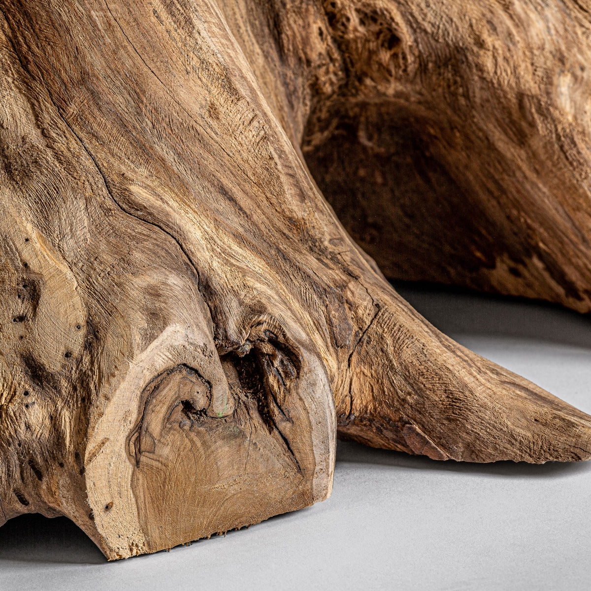 Detalle del tronco curvo tallado de forma natural, con imperfecciones que refuerzan su carácter artesanal.