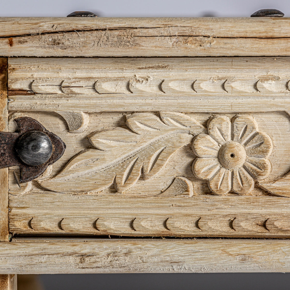 Detalle de esquina con remaches metálicos oscuros y veta de madera natural, mesa CHIZHIA.