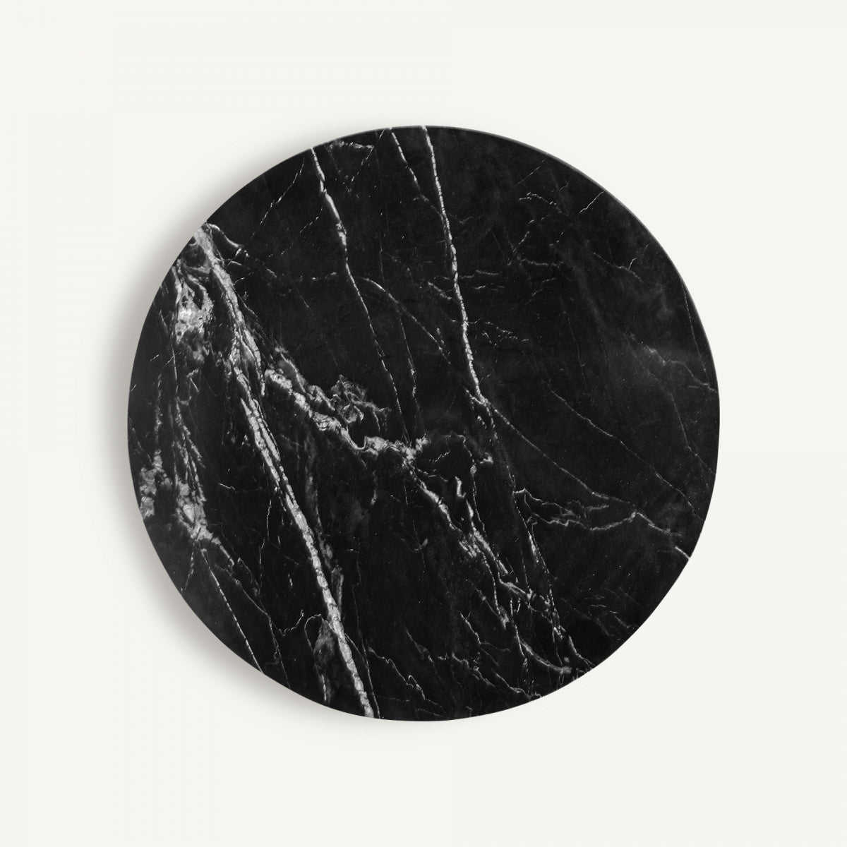 Vista cenital de mesa redonda con vetas blancas sobre mármol negro, ideal para comedores elegantes