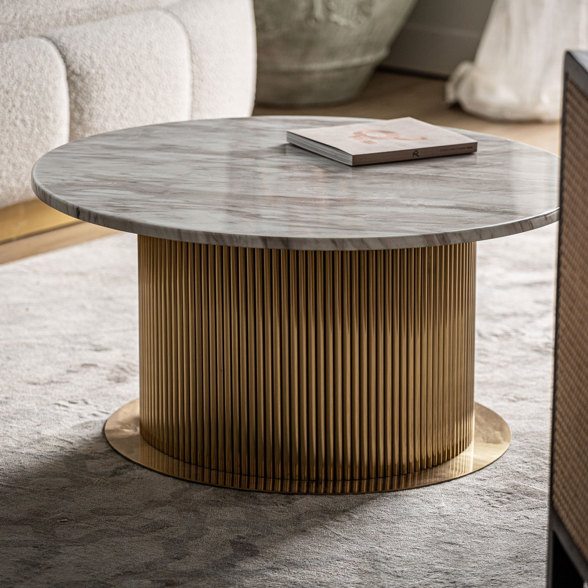 Mesa de centro de mármol y base dorada en salón contemporáneo con sofá y alfombra neutra – boutique interiorismo VICAL