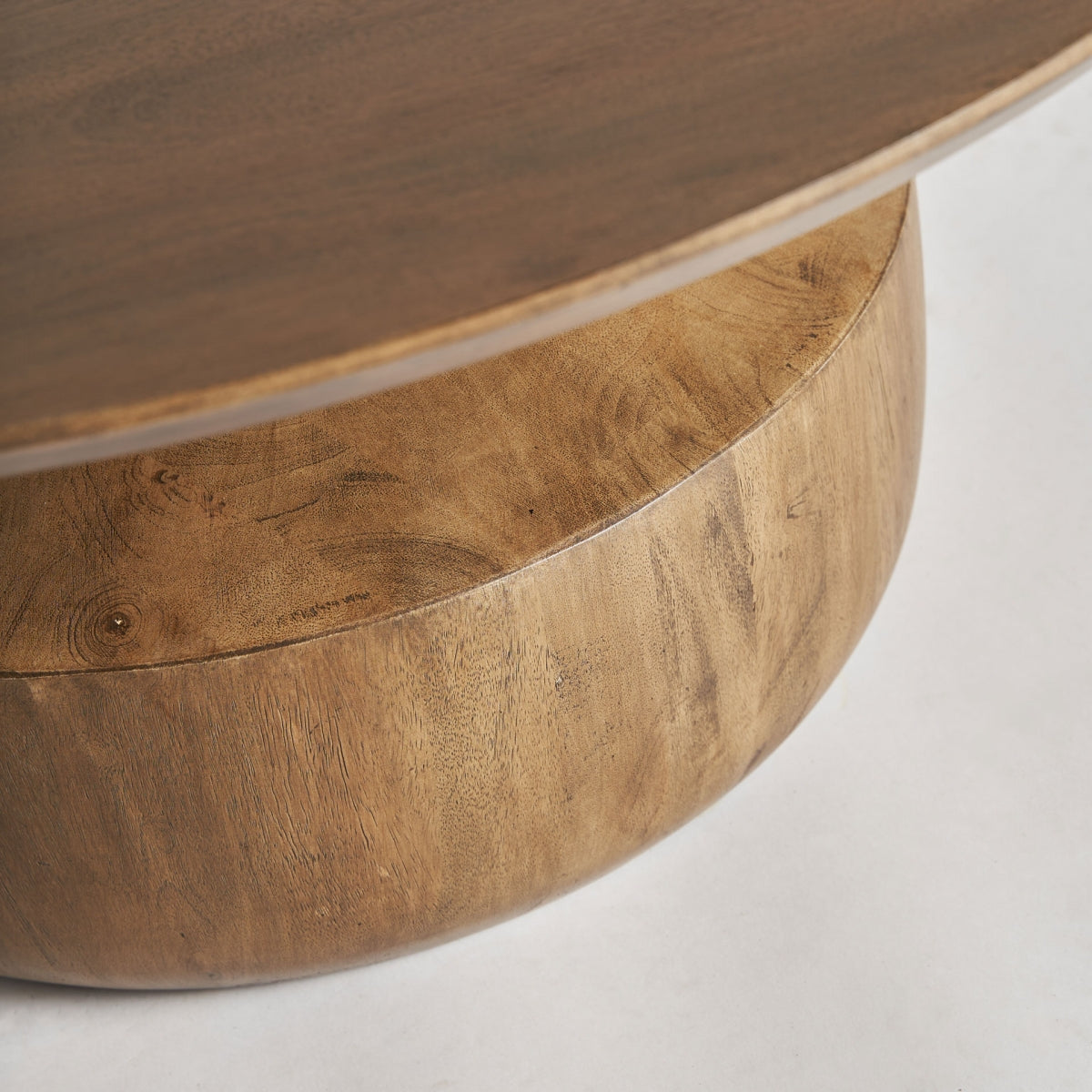 Primer plano de la base curva en madera de mango, volumen escultórico con textura noble.