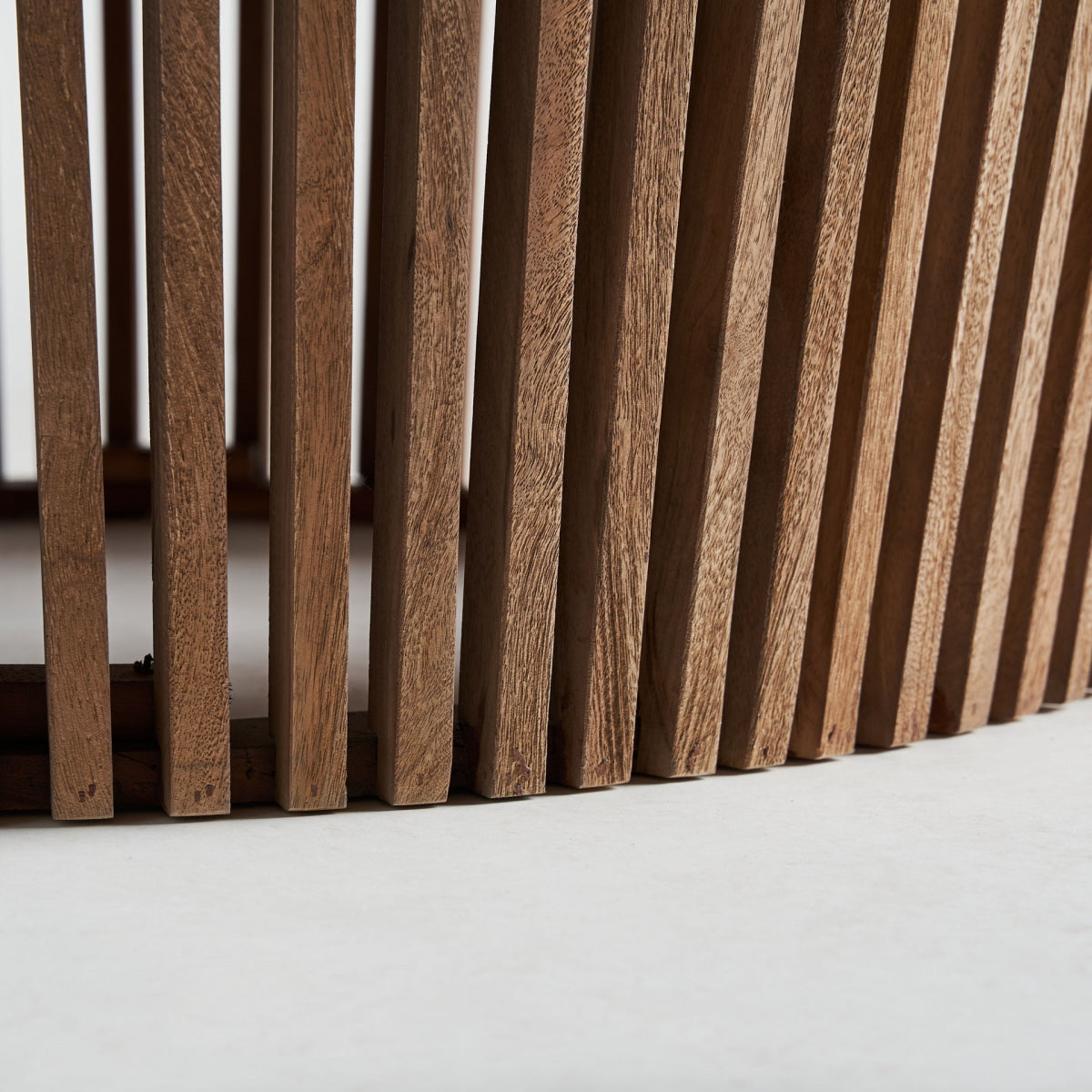 Detalle de las lamas verticales de madera natural que forman la base de la mesa de centro