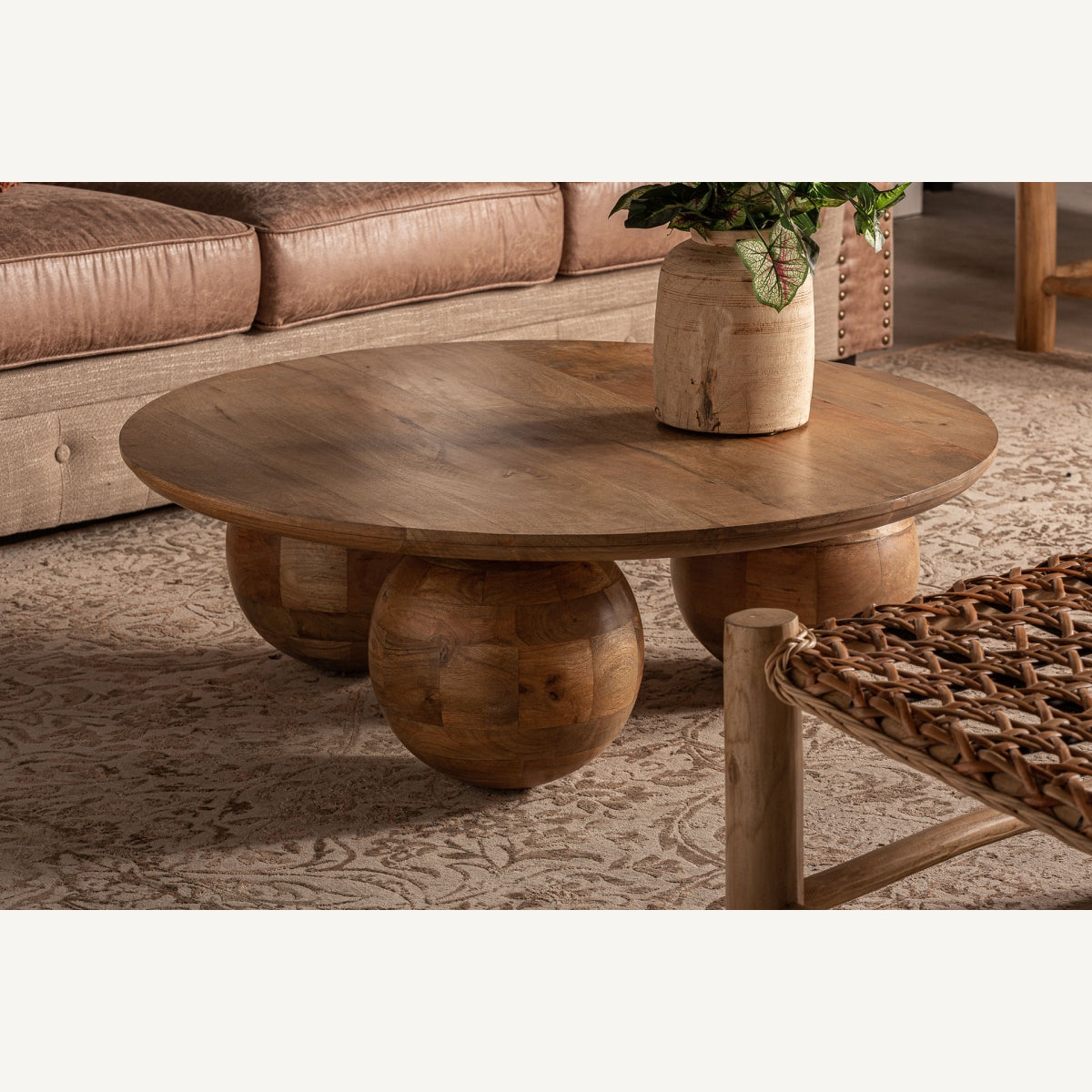 Mesa de centro de madera redonda decorando salón rústico chic con sofá y alfombra beige – boutique interiorismo VICAL