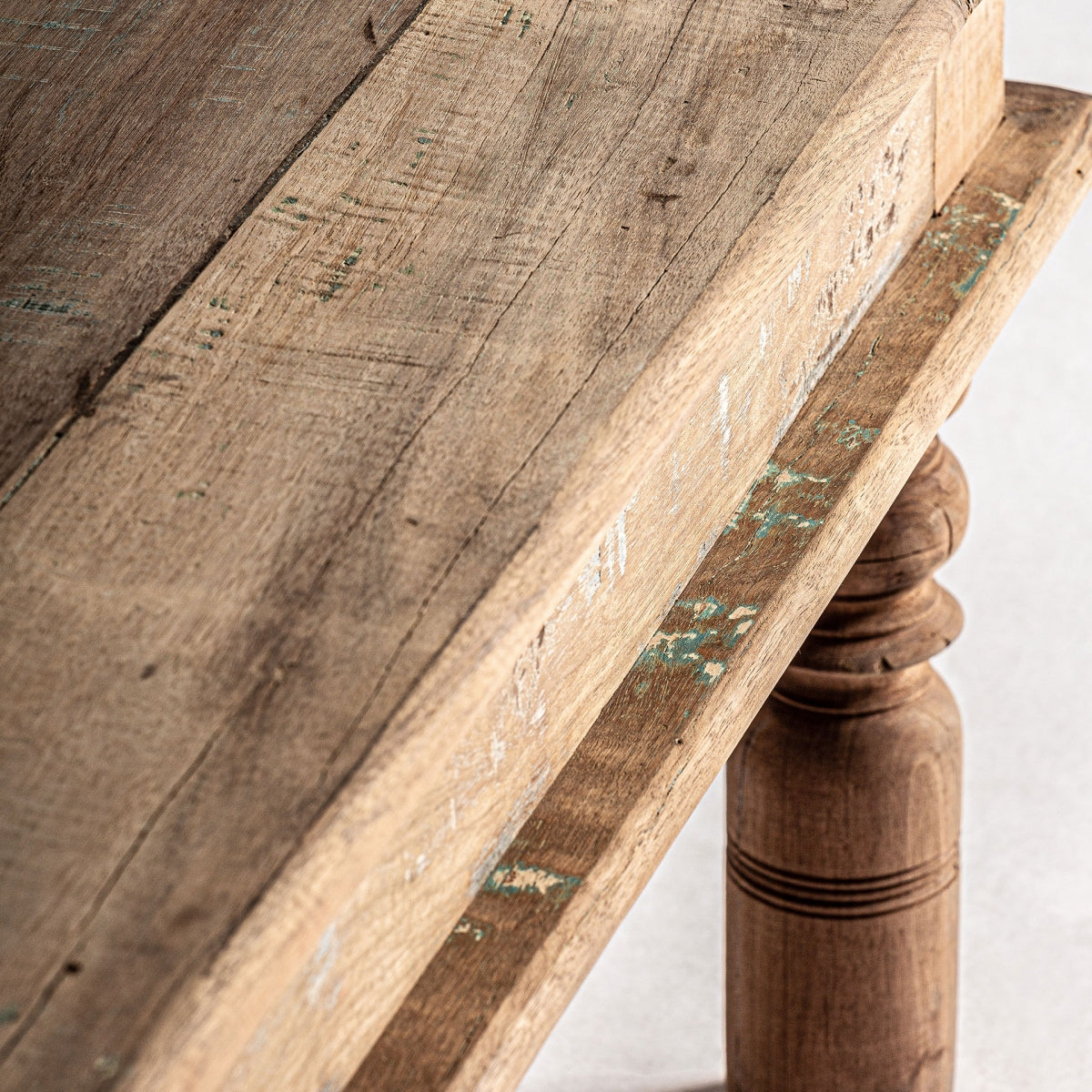 Detalle de pata torneada en madera maciza con decapado en tonos verdes y blancos.
