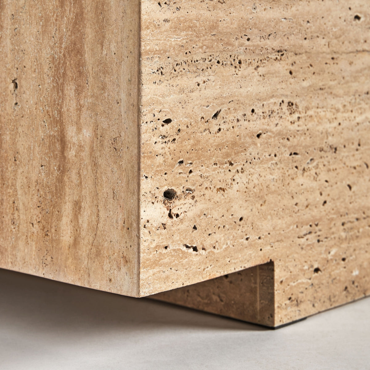 Vista de la base lateral de la mesa NORDDAL con textura de piedra travertino – estructura sólida boutique interiorismo Vical