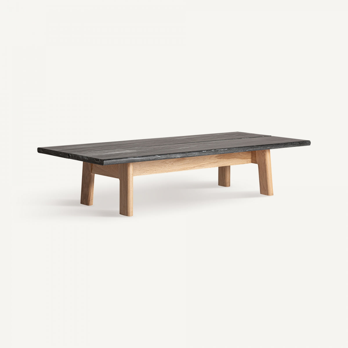 Mesa Nara rectangular en vista tres cuartos, diseño sobrio en piedra negra con base de madera clara
