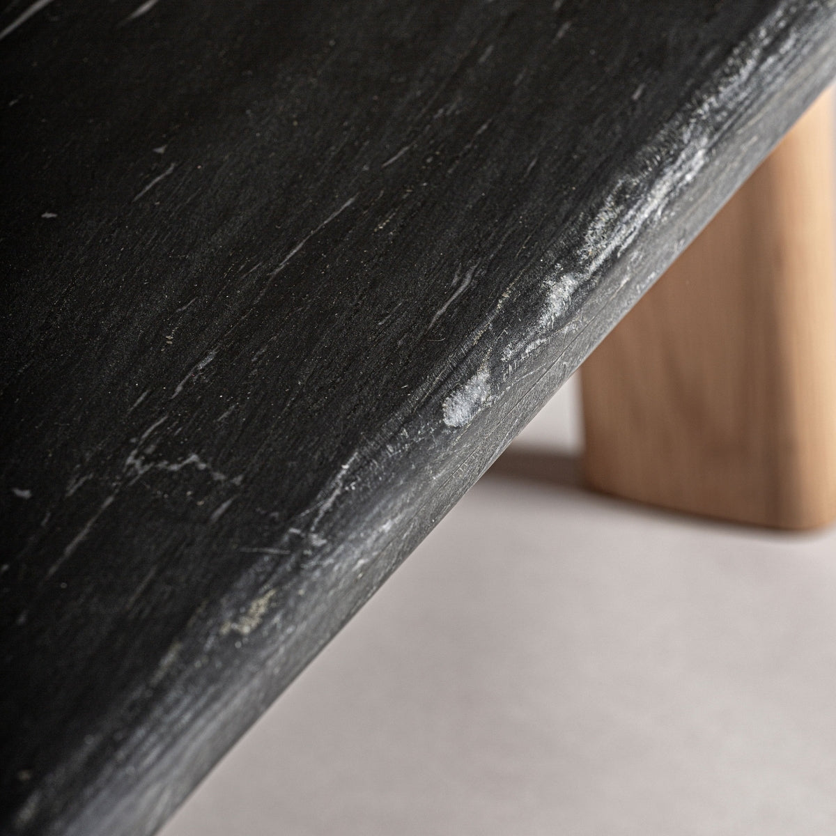 Detalle de textura rugosa y vetas de la piedra negra del sobre de la mesa Nara