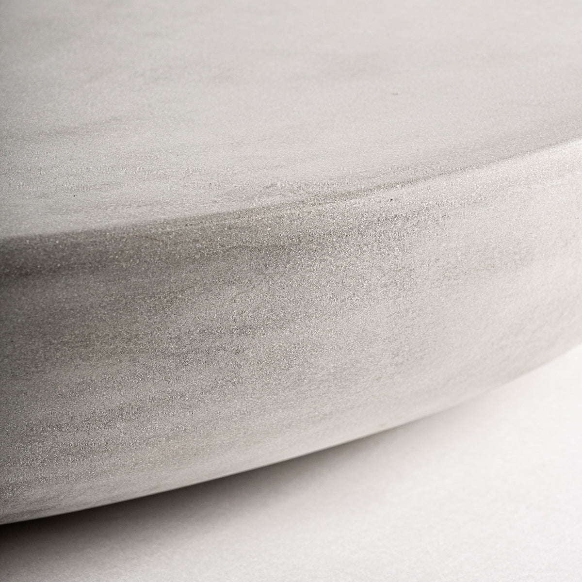 Detalle del canto redondeado en la superficie de la mesa CLESS, con textura sutil y natural