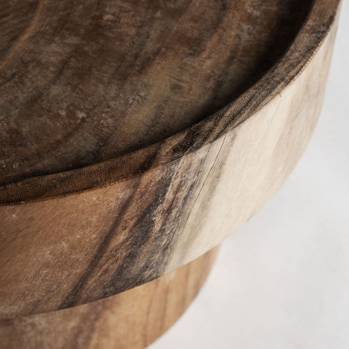 Vista superior de mesa auxiliar en madera natural con vetas café y forma escultórica moderna.