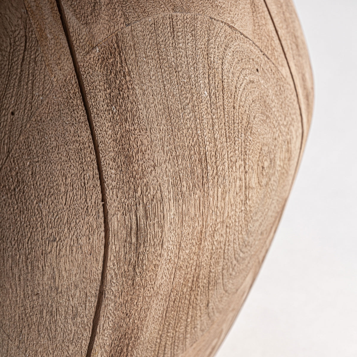 Detalle de la base geométrica en madera maciza, textura cálida y natural