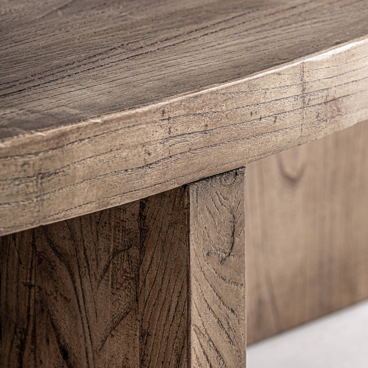 Detalle del borde curvado de la tapa de madera maciza, con textura marcada y acabado natural.