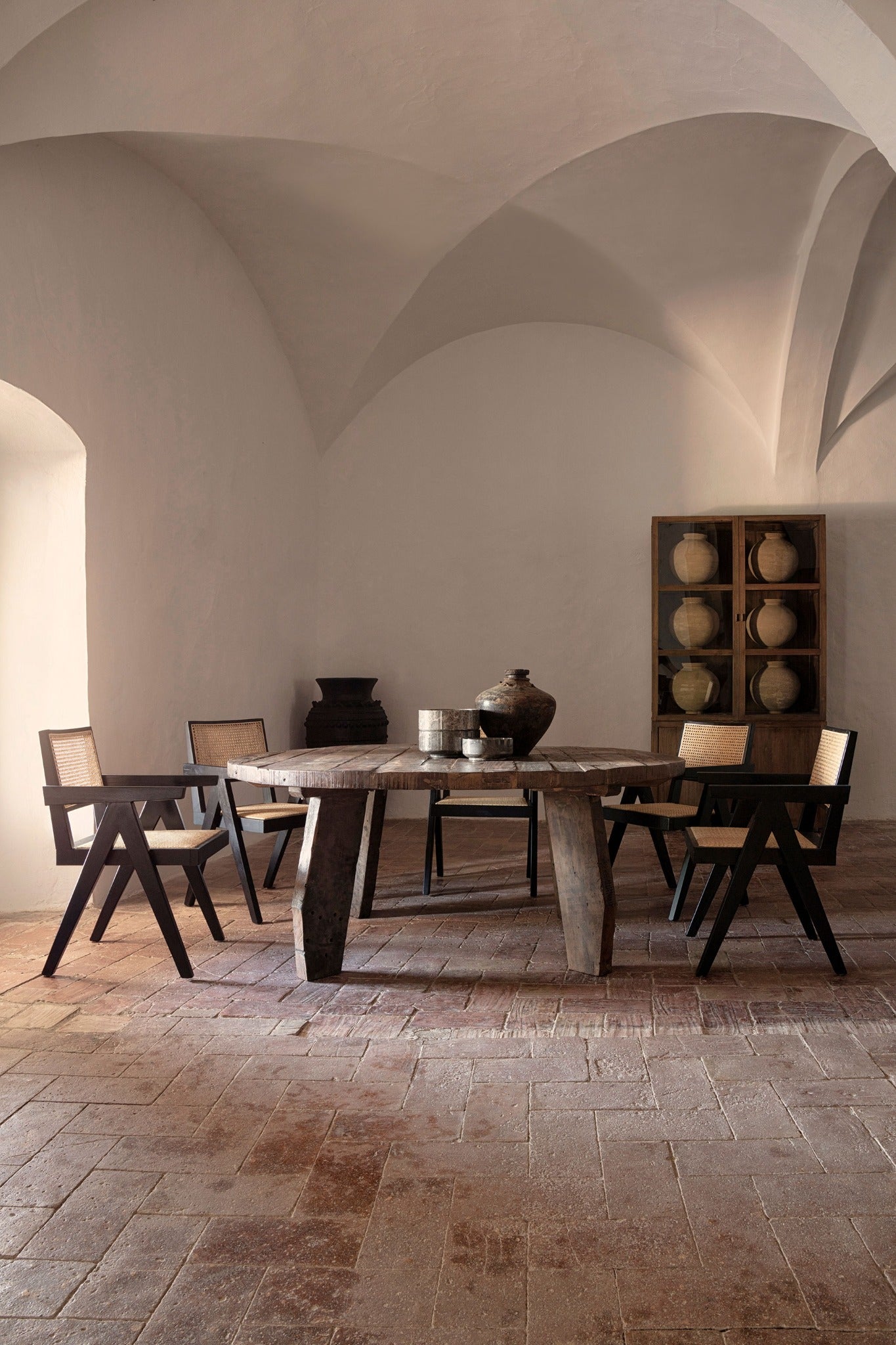 Mesa de comedor Hassi en ambiente mediterráneo sobrio con sillas negras y jarras cerámicas – boutique interiorismo VICAL