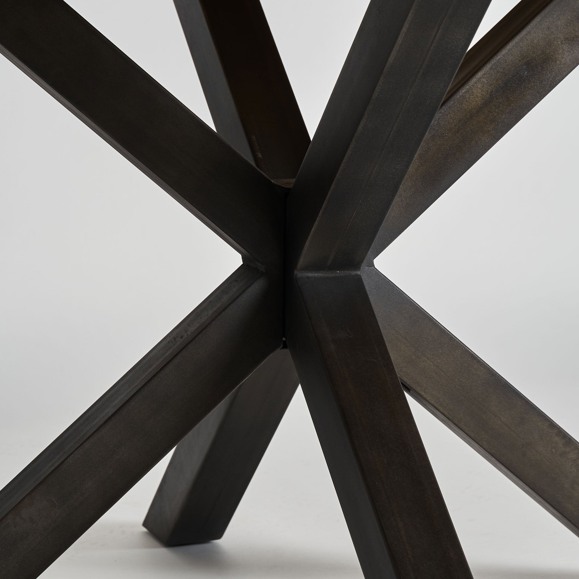 detalle estructura metálica negra cruzada base mesa redonda boutique_interiorismo-vical