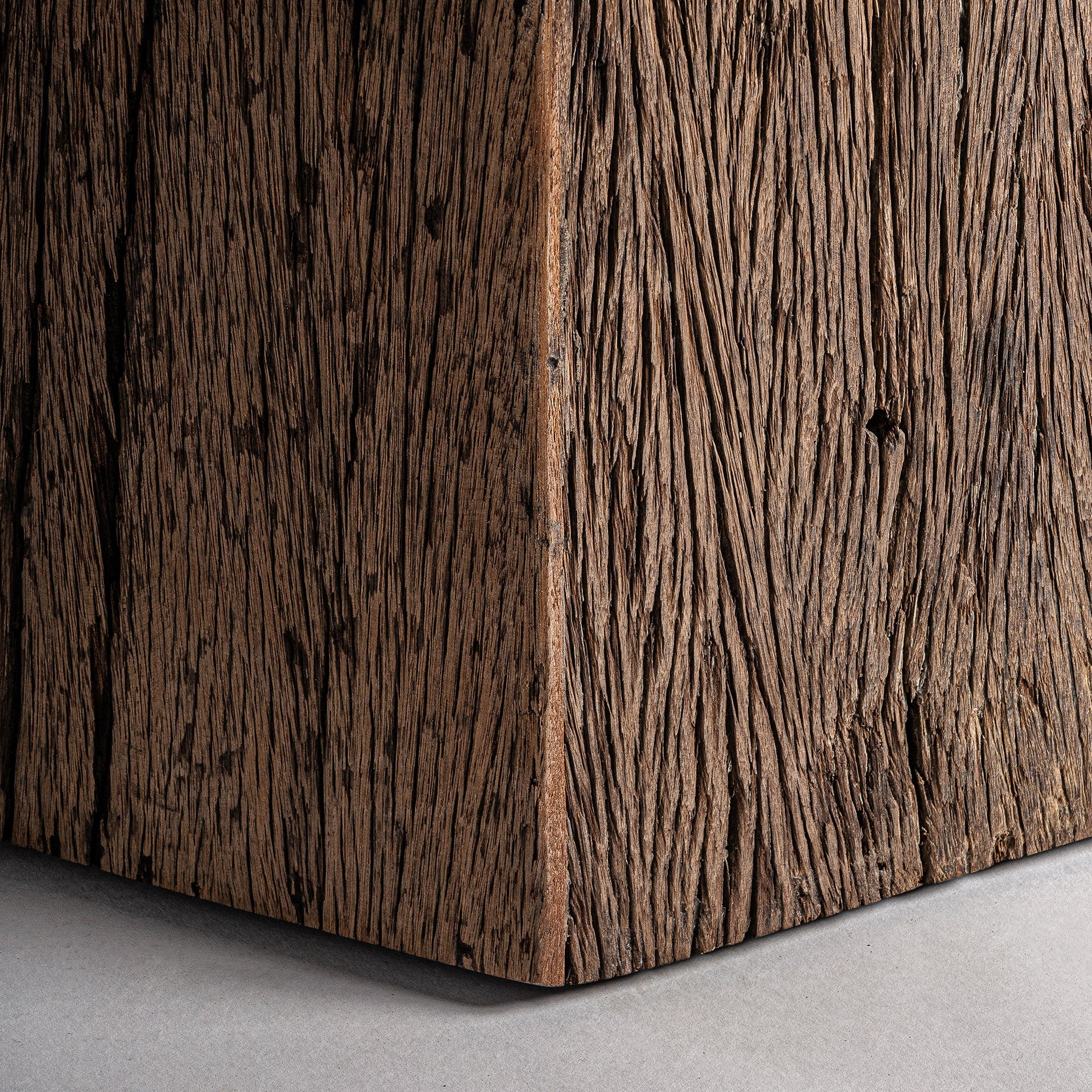 Detalle de la base facetada de madera reciclada natural, diseño orgánico y robusto