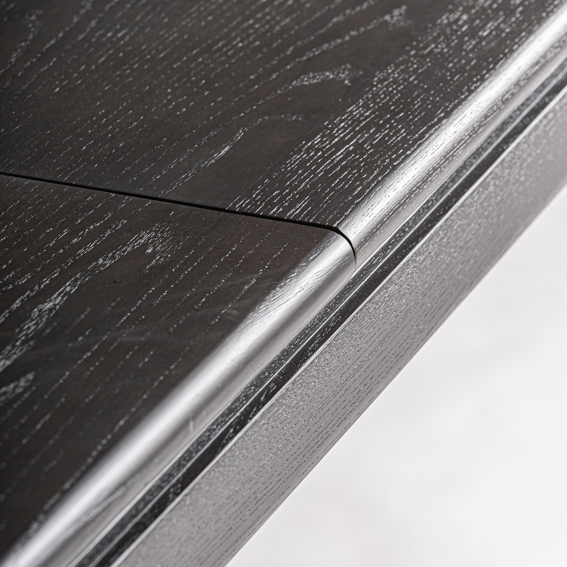 Detalle de la unión del tablero extensible en madera de ébano mate