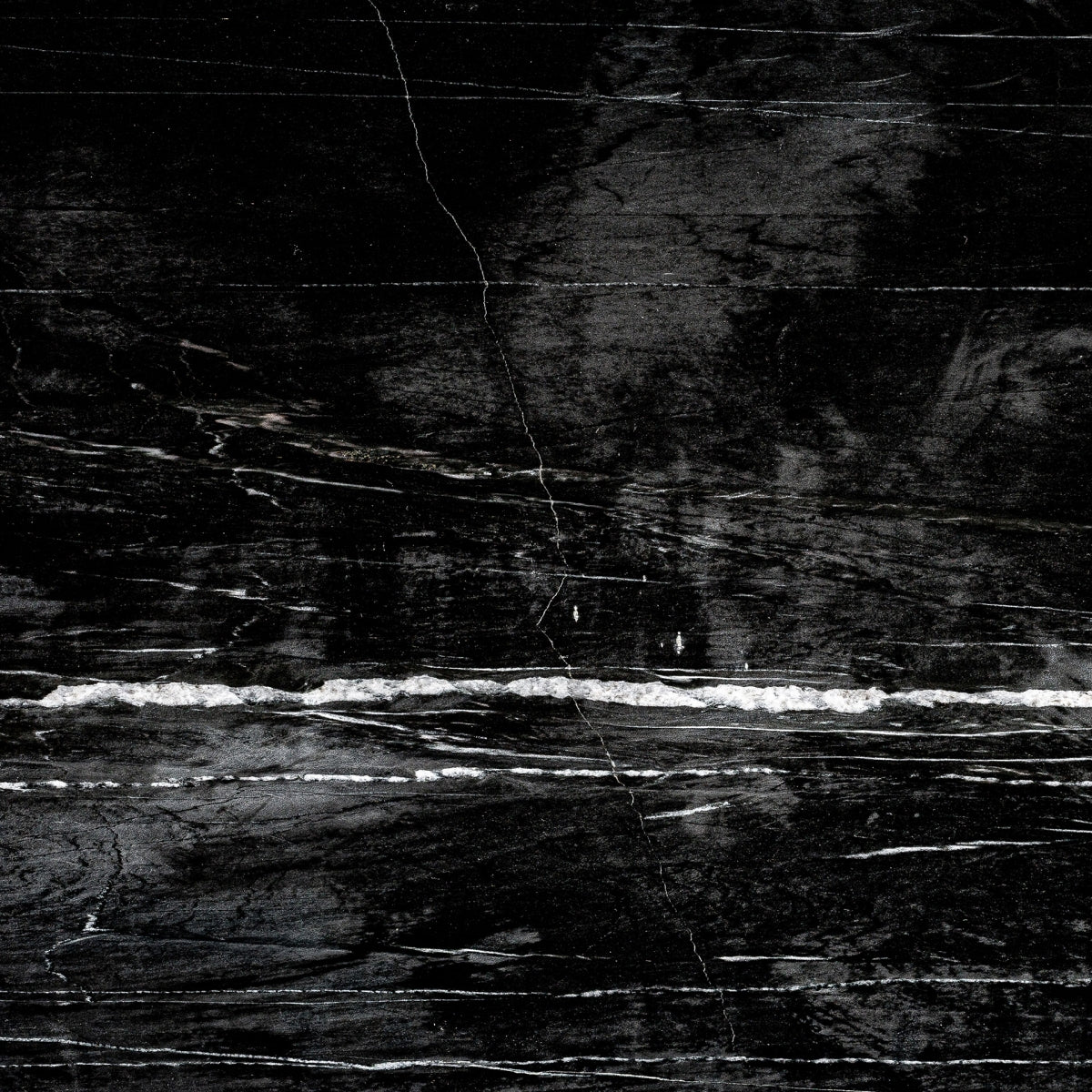 Primer plano de la veta de mármol negro del sobre del escritorio Plissé.
