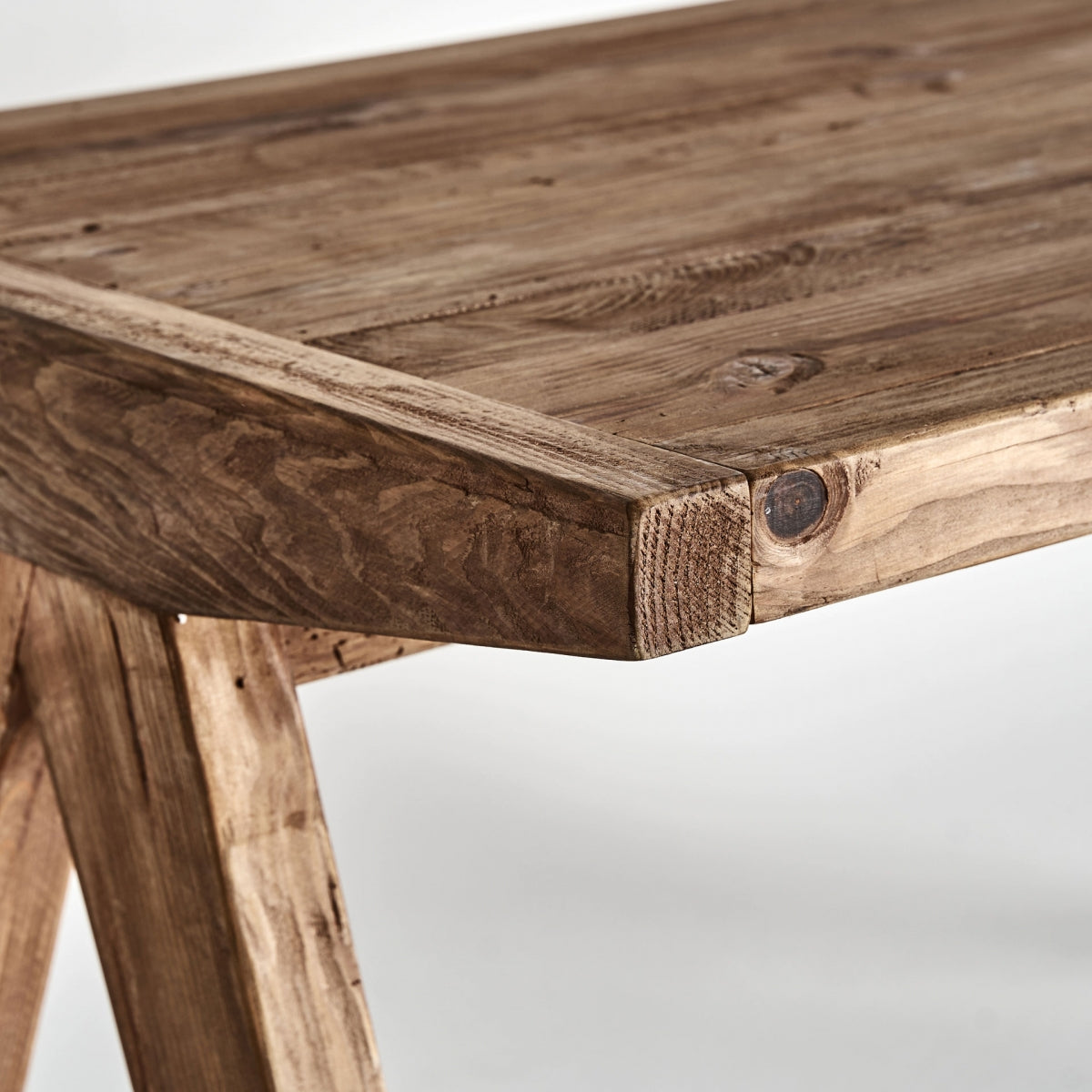 Detalle de la esquina del tablero con vetas marcadas, madera reciclada en acabado natural
