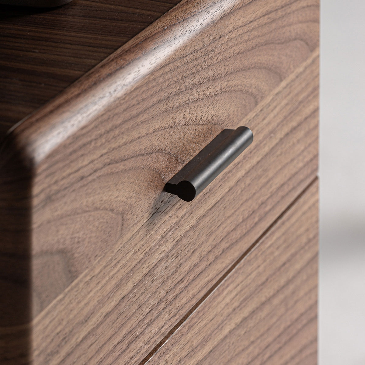 Tirador metálico negro sobre cajón de madera marrón, detalle de diseño art déco sofisticado