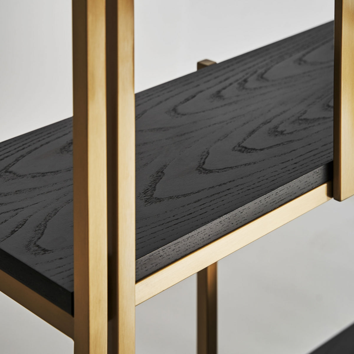 Primer plano de las baldas de roble oscuro con estructura art déco dorada