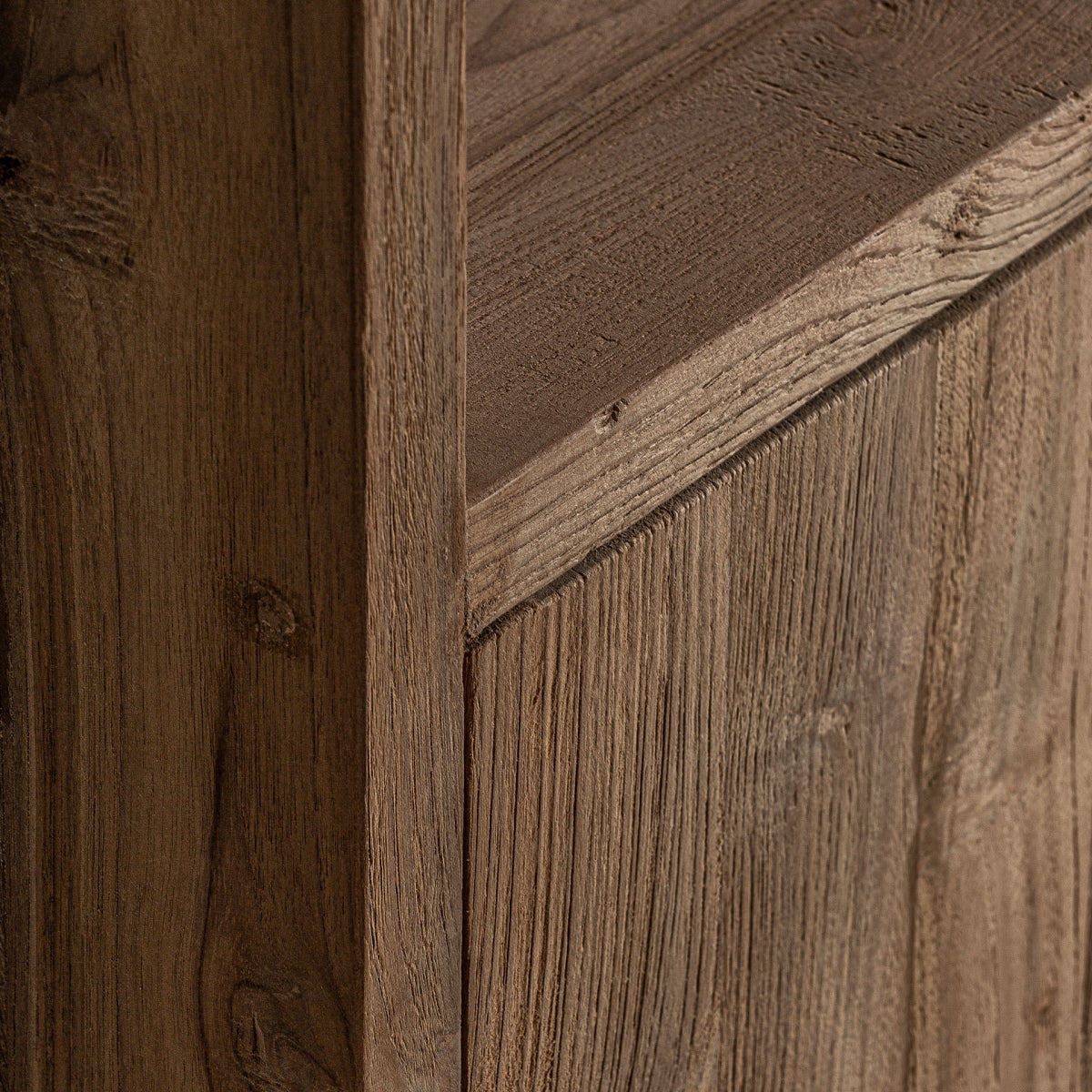Detalle cercano de la textura de la madera de teka en acabado marrón, diseño robusto y natural.