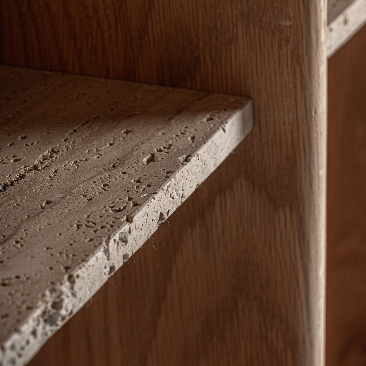 Detalle de balda en piedra travertino natural sobre fondo de madera de roble – estantería Nara de diseño