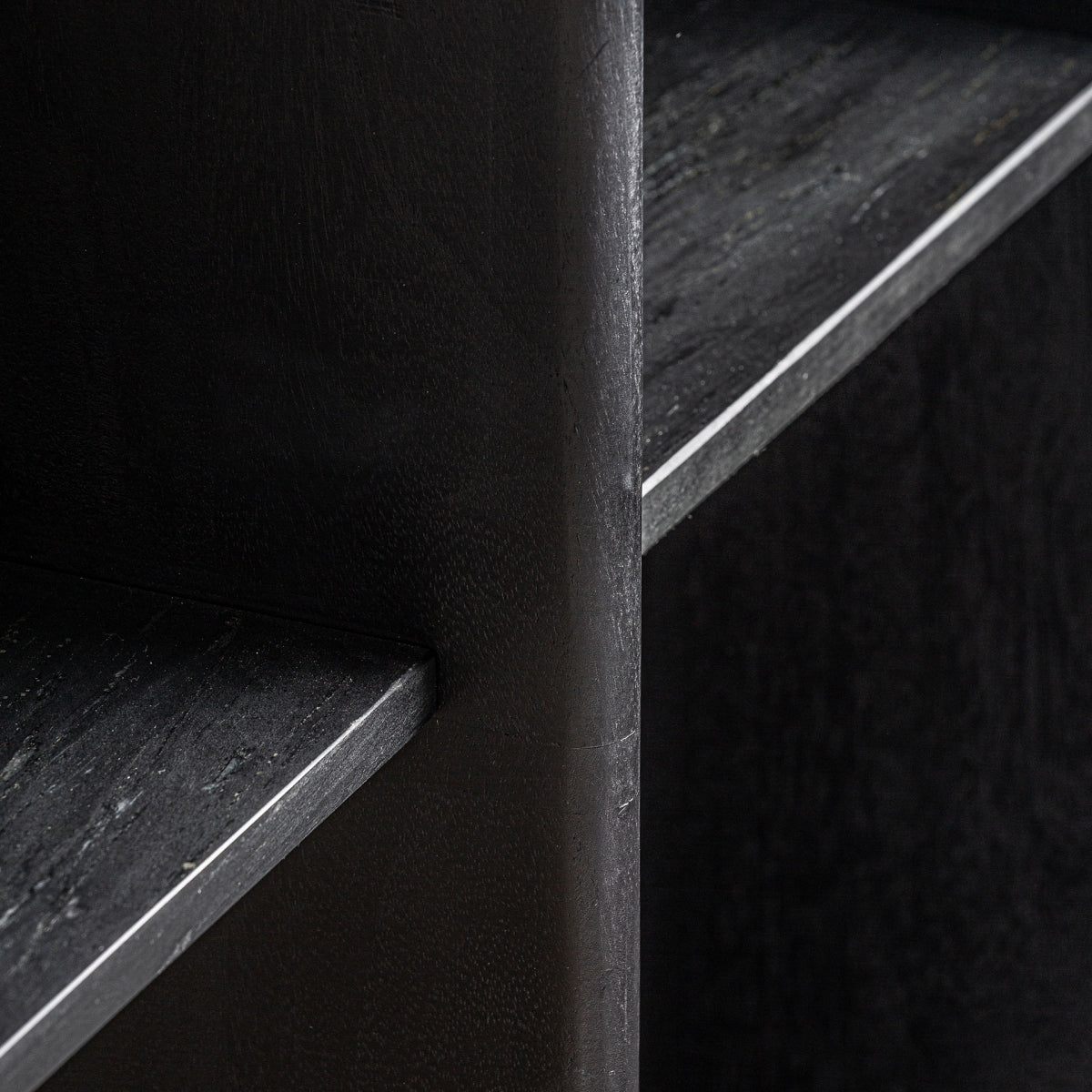 Detalle del roble teñido en negro de la estantería Columnar – tacto natural y estética minimalista