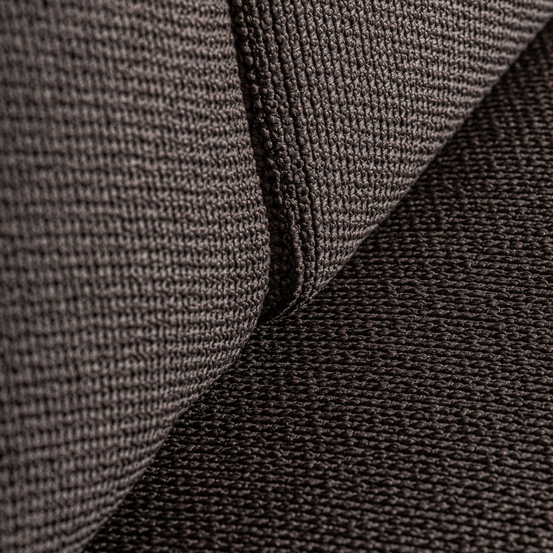 Vista lateral del sofá Corba con curvas continuas que envuelven el asiento, elegancia natural.